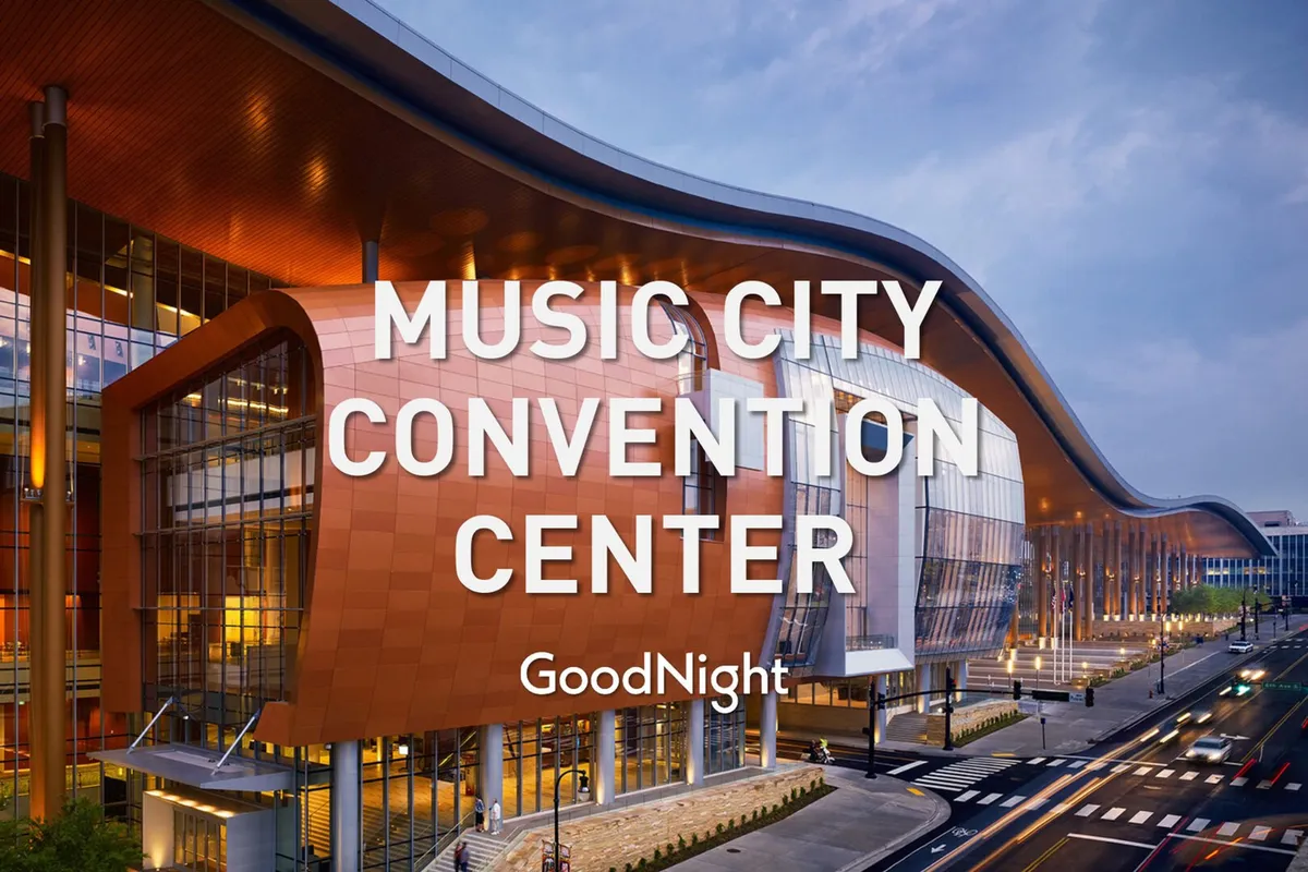 A close-up of the Music City Center's distinctive curvilinear roof and glass facade, bustling with activity near the entrance. The convention center atmosphere is energetic and welcoming, connecting guests to major business events and gatherings.