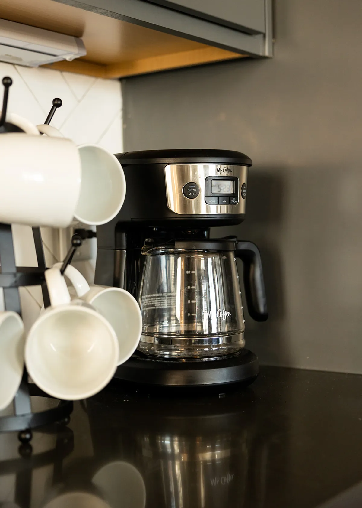 A close-up of a coffee maker and mugs set on a kitchen counter. The scene captures the inviting ritual of morning coffee and hints at the GoodNight Stay starter coffee set, with a focus on hospitality and comfort.