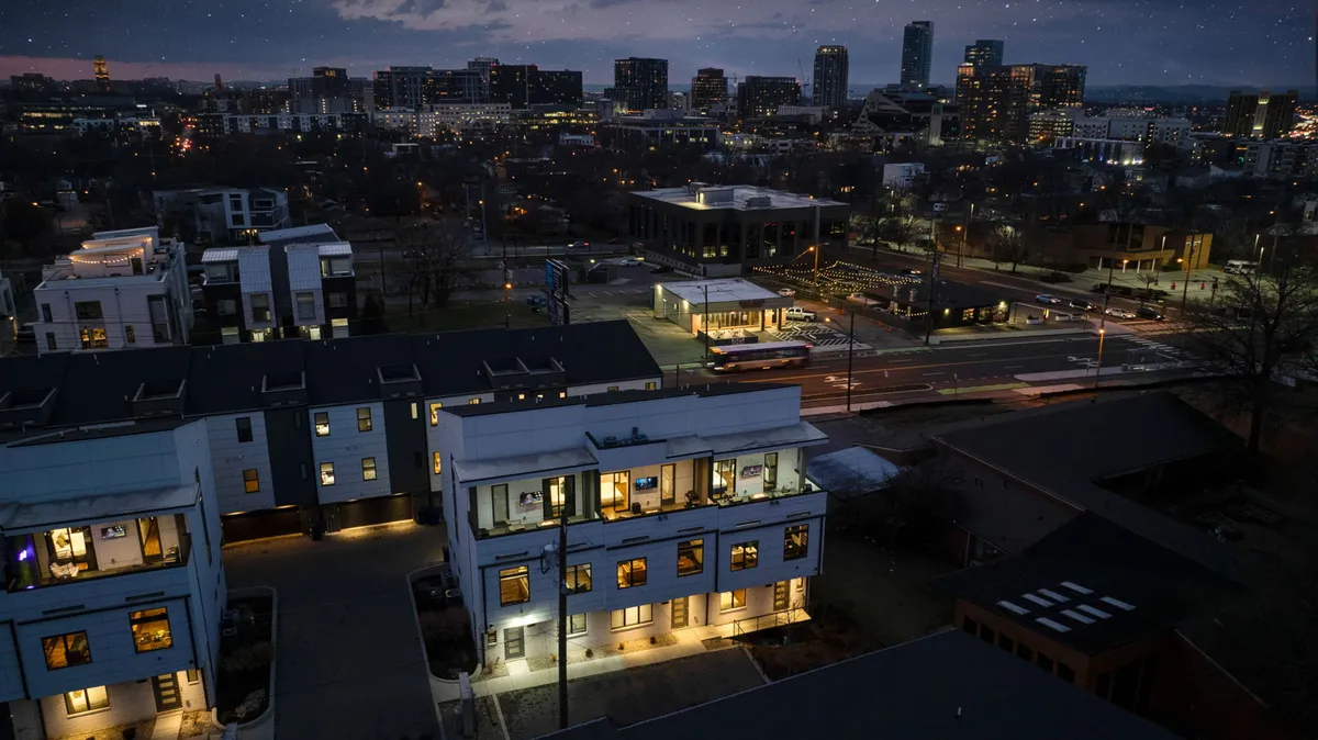 This image captures the modern buildings of Nashville’s downtown area, with illuminated windows and a vibrant city skyline in the background. Street lights line the roadway, emphasizing the energetic and contemporary urban environment.