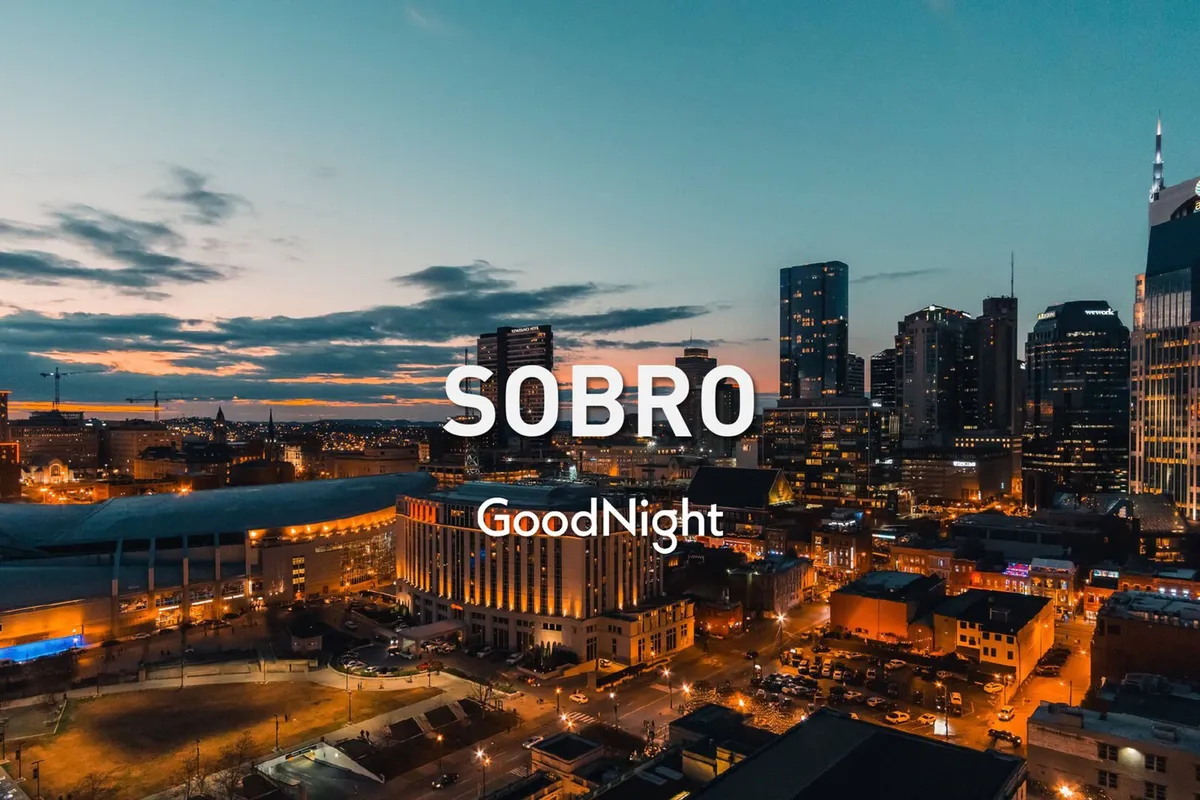 A sweeping view of the Nashville city skyline at sunset, with the lights of buildings beginning to twinkle as dusk falls. The horizon is illuminated in warm hues, evoking the anticipation of an exciting evening in the city.